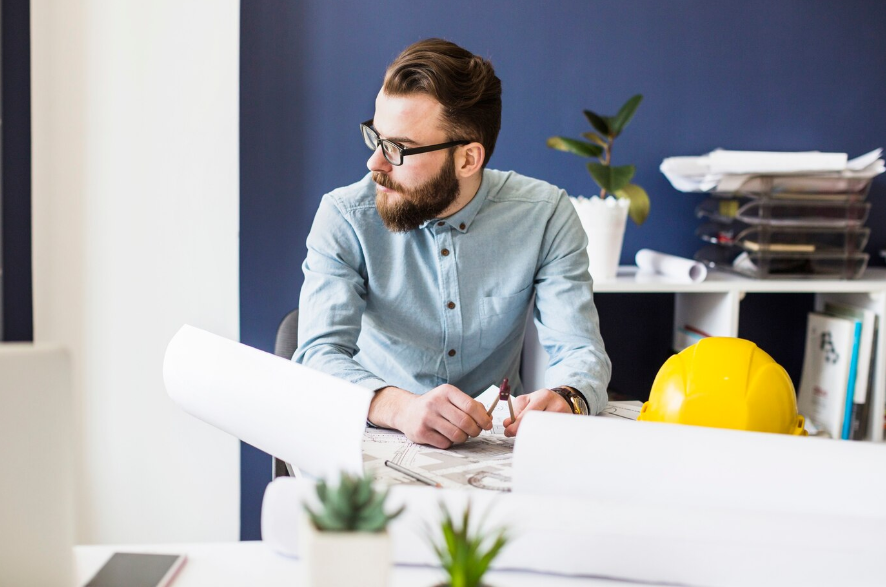 An engineer carefully reviews architectural plans, ensuring every detail aligns with the project's blueprint